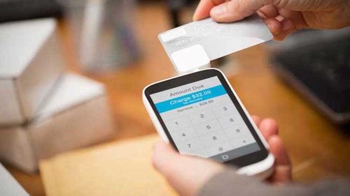 Person scanning a credit card on a smartphone.