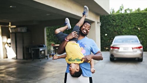 Dad and son having fun in the driveway.